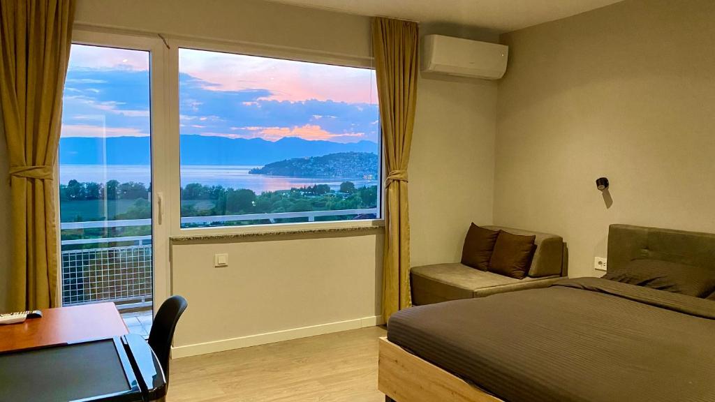 a bedroom with a bed and a large window at Villa Megdani A in Ohrid