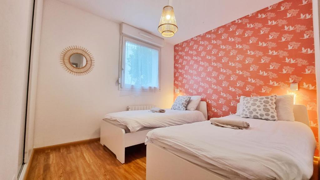 une petite chambre avec deux lits et une fenêtre dans l'établissement Chez Margot & Fawaz - Parking - 3 chambres - Jardin - Relax BNB, à Colmar
