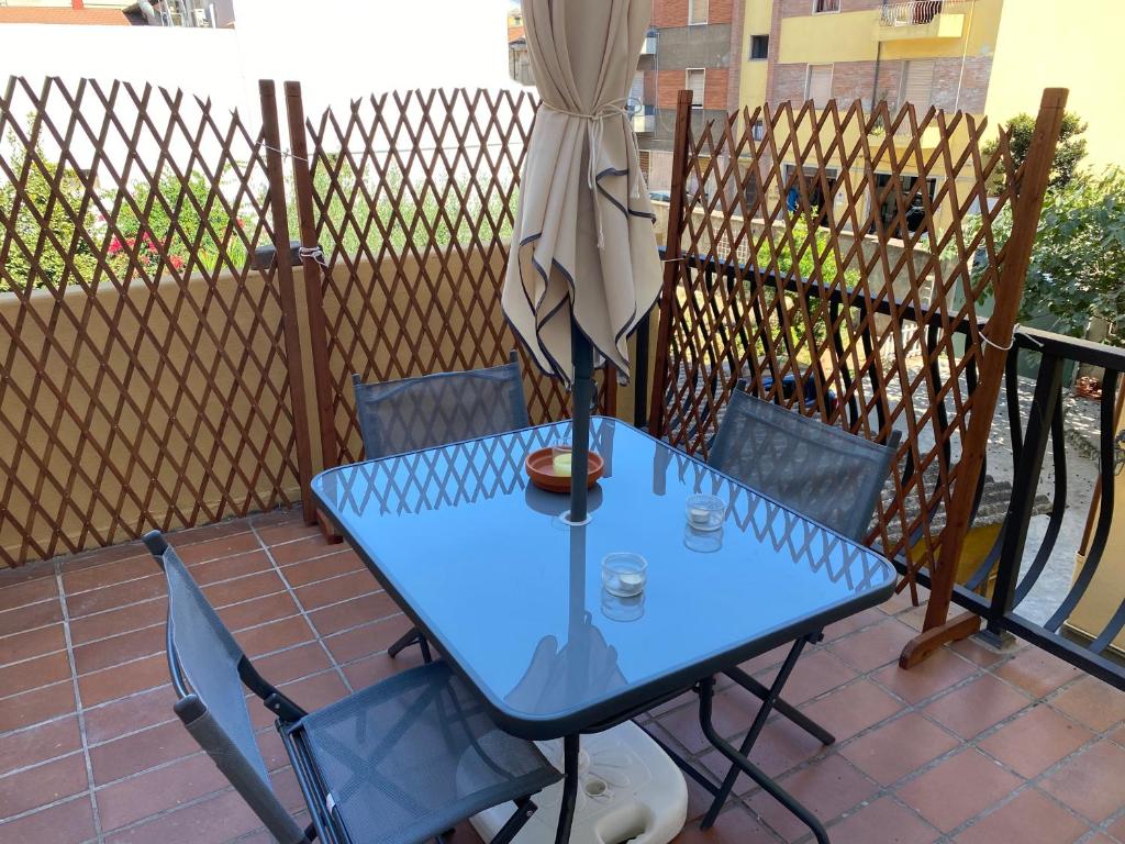 a blue table with two chairs and an umbrella at Civico10, appartamento centrale con parcheggio e terrazzo in Piombino