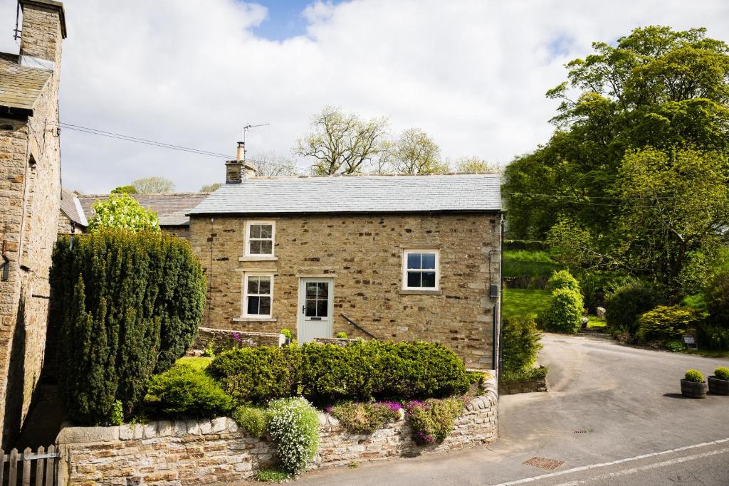 a brick house with a stone wall and a driveway at Low Thearns in Barnard Castle