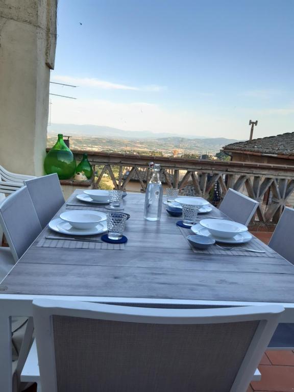 uma mesa de madeira com cadeiras e pratos em Appartamento Viola 27 em Perugia
