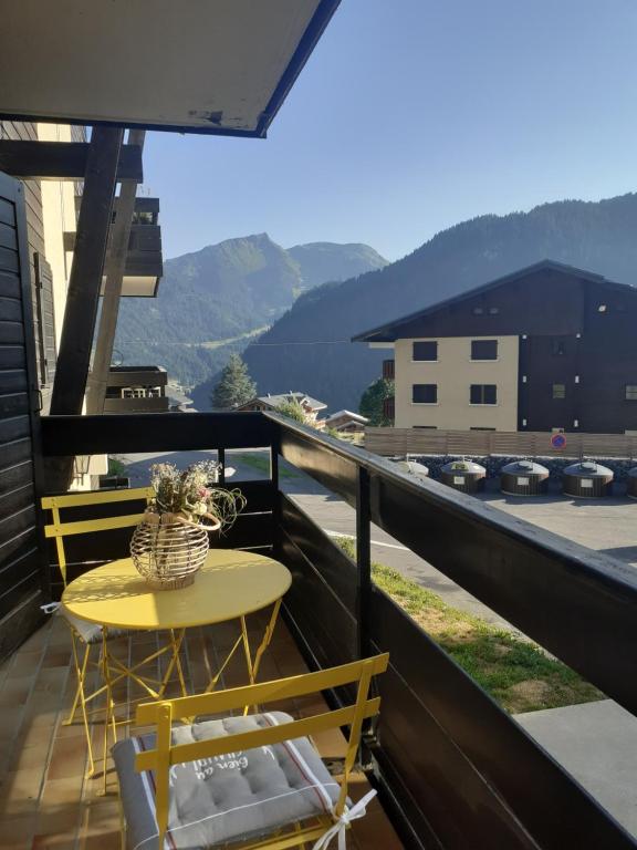 a table and chairs on a balcony with a view at studio cabine Chatel in Châtel
