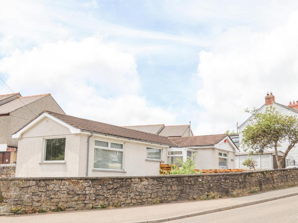 Casa blanca con pared de piedra en Apple Tree Bungalow en Redruth