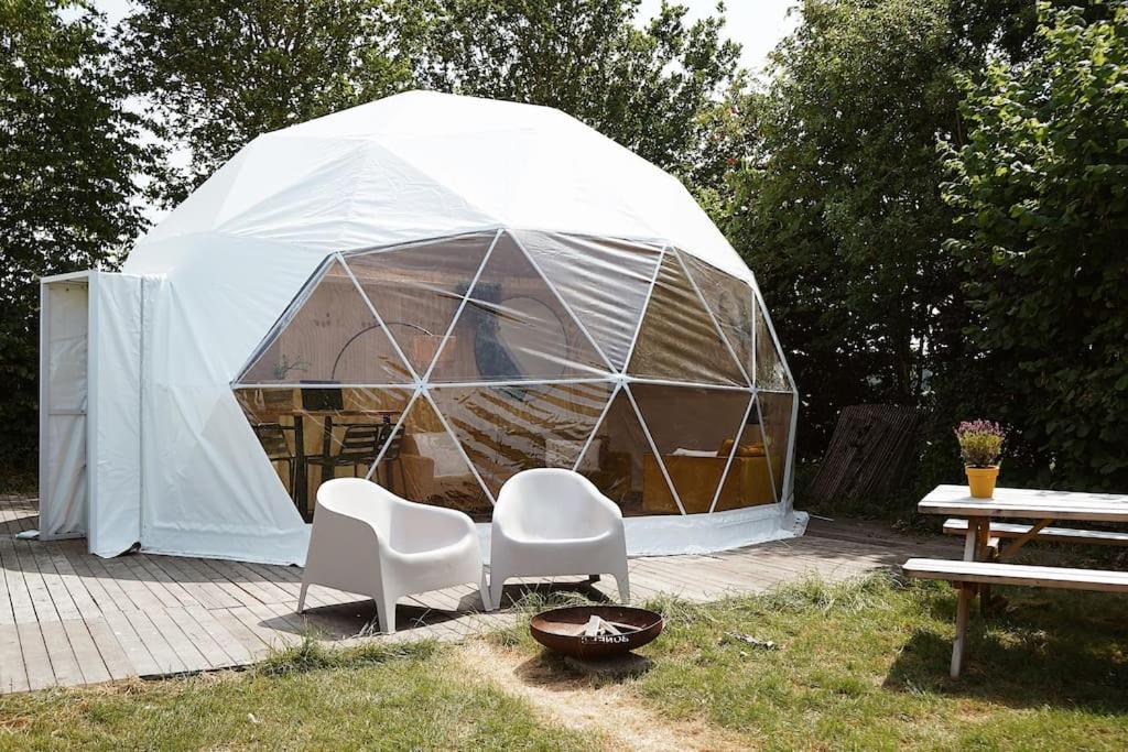 een tent met twee stoelen en een tafel ervoor bij Glamping Dome Tent in Jubbega-Schurega