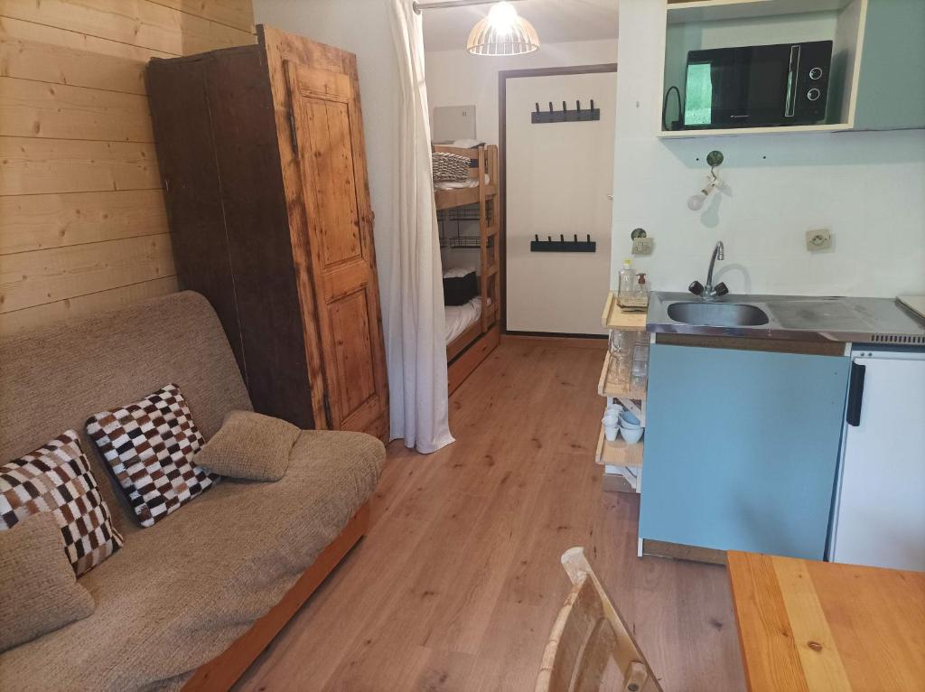 ein Wohnzimmer mit einem Sofa und einer Küche in der Unterkunft Studio Morillon Village in Morillon