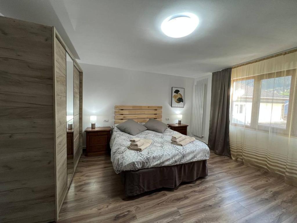 ein Schlafzimmer mit einem Bett und einem großen Fenster in der Unterkunft Ambra Dream Home in Câmpulung Moldovenesc