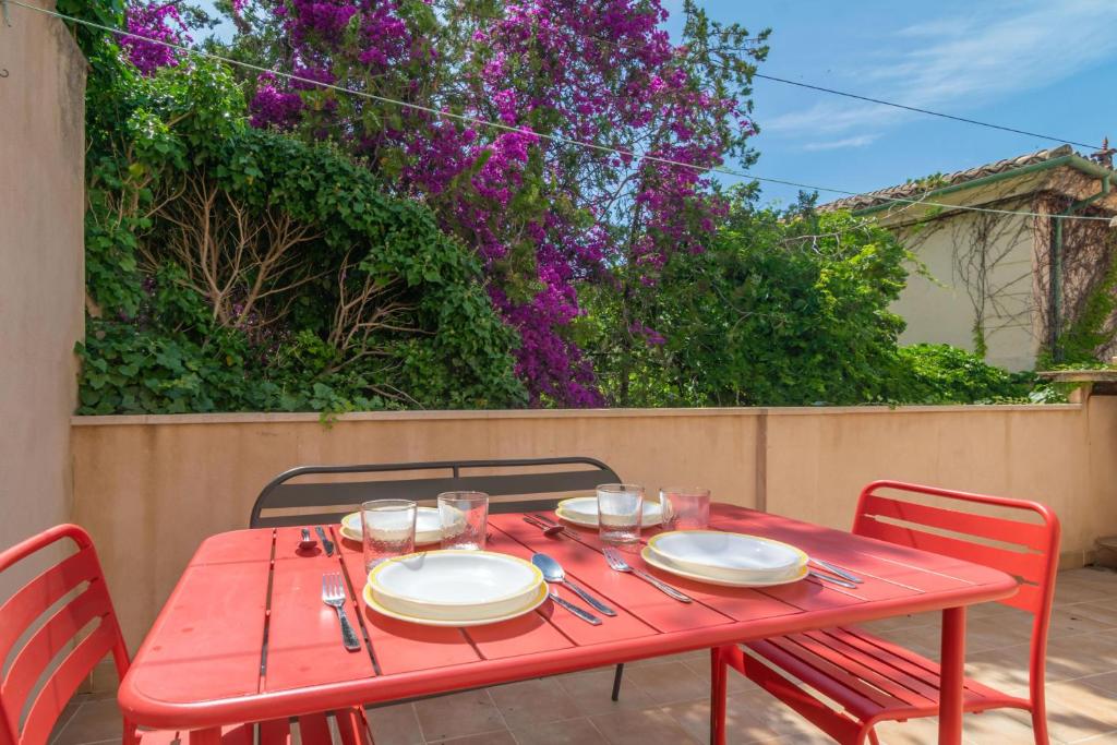 a red table with chairs and plates on it at Ca's Pobres in Sóller
