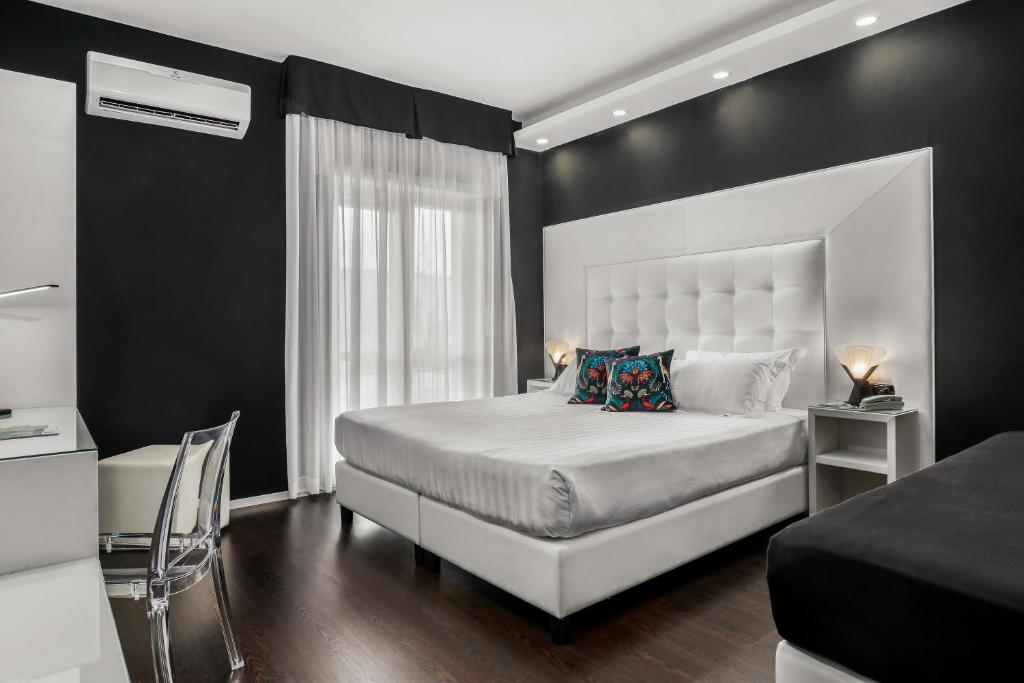 1 dormitorio con cama blanca y pared negra en Reggia Suite Spa Hotel, en Caserta