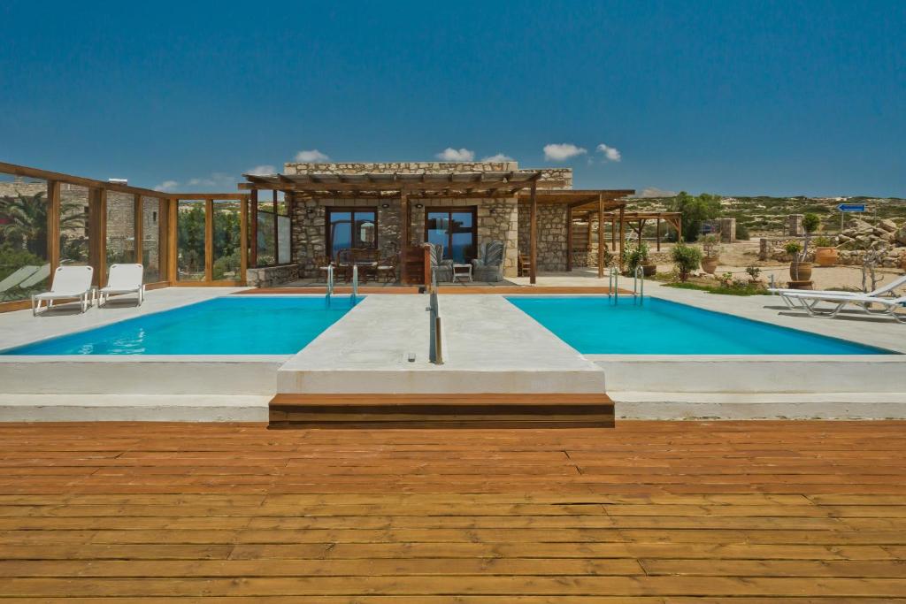 a villa with a swimming pool and a house at Michaliou Kipos Luxury Villas in Afiartis