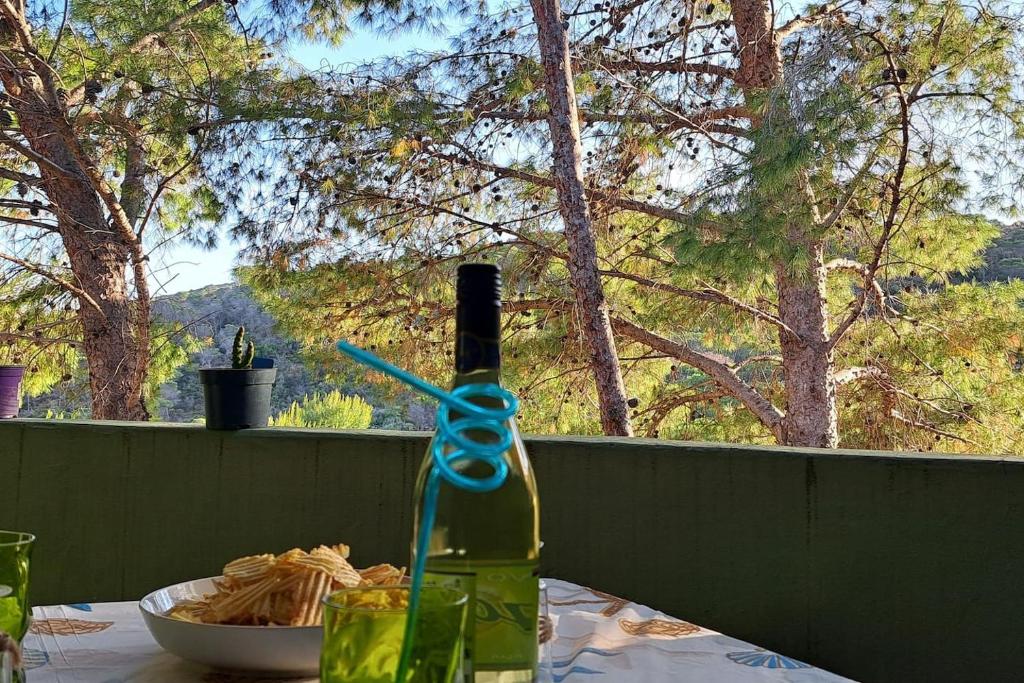 una bottiglia di vino su un tavolo con una ciotola di pasta di DomuNosta Pinus Village a Santa Margherita di Pula