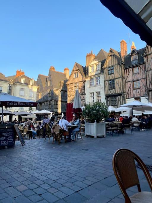 a group of people sitting at tables in a courtyard at T2 vue sur La Place Plumereau in Tours