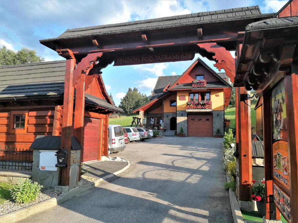 an entrance to a building with cars parked in a parking lot at Penzion pod Tatrami in Ždiar