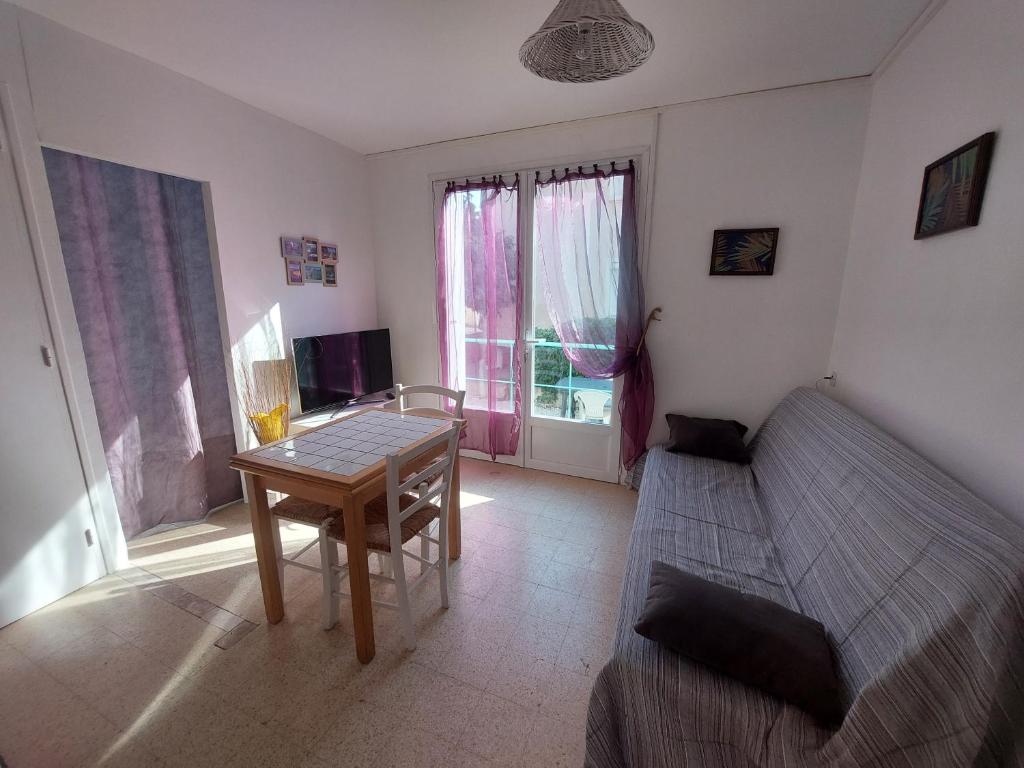 un salon avec un canapé et une table dans l'établissement Appartement 1mn de la plage, à Valras-Plage