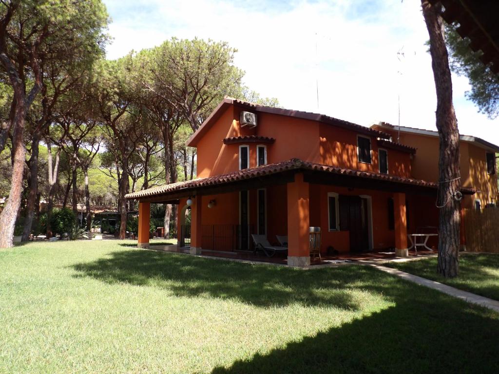 uma casa com um relvado verde em frente em Le Due Tortore Home Holiday - Villa con splendido giardino ad un minuto a piedi dal mare em Fort Village