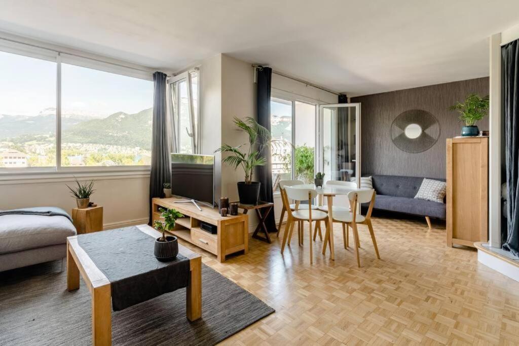 un salon avec un canapé et une salle à manger dans l'établissement Le Panorama - Vue Lac et Montagne avec parking, à Annecy