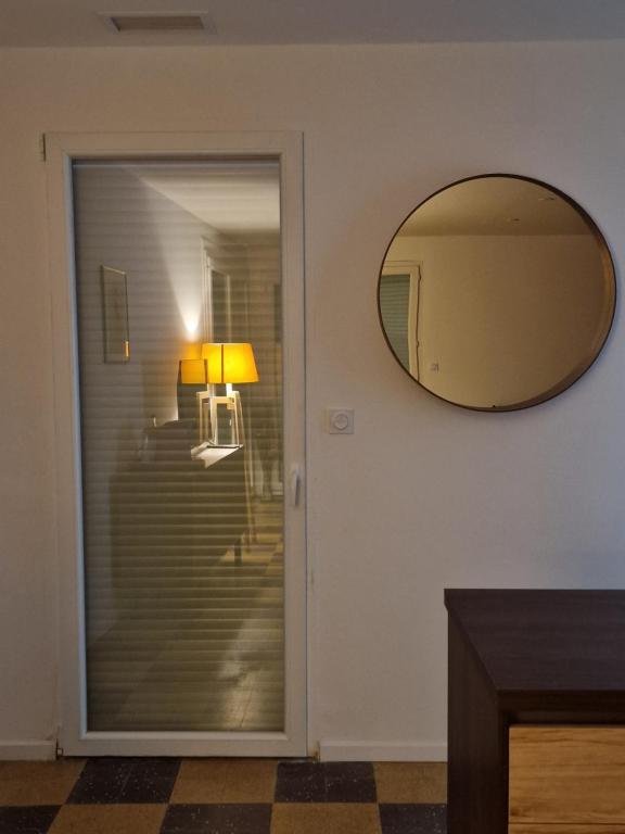 a mirror on a wall next to a door at maison PING ,en face des arènes in Béziers