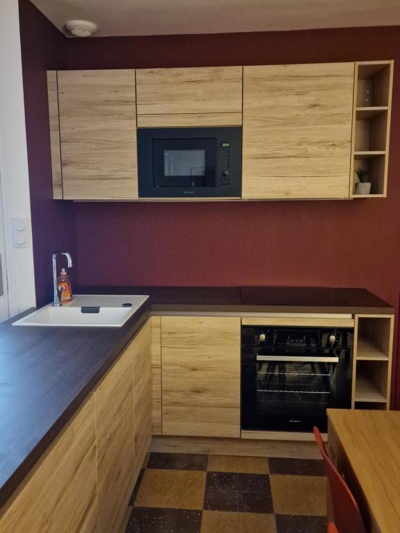 a kitchen with a sink and a microwave at maison PING ,en face des arènes in Béziers