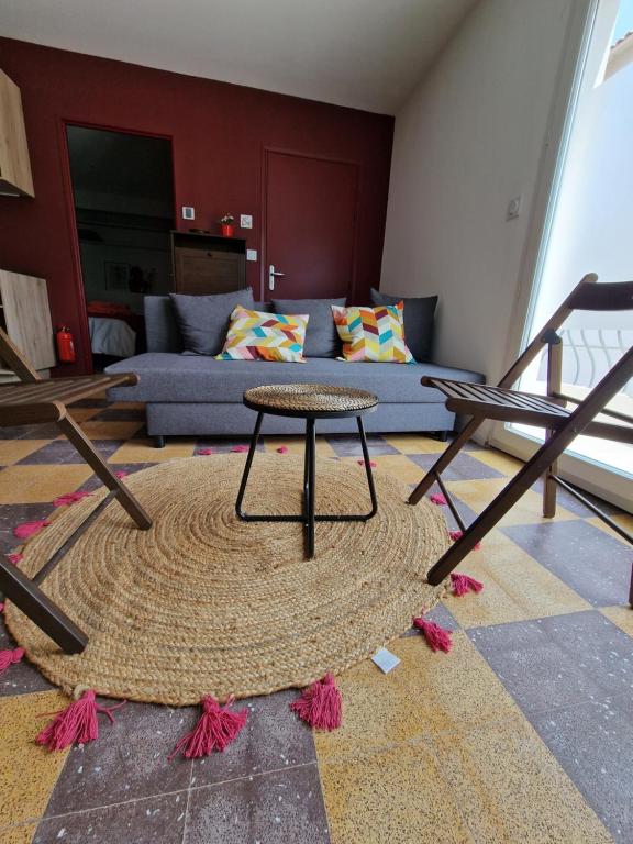 a living room with a table and a couch at maison PING ,en face des arènes in Béziers