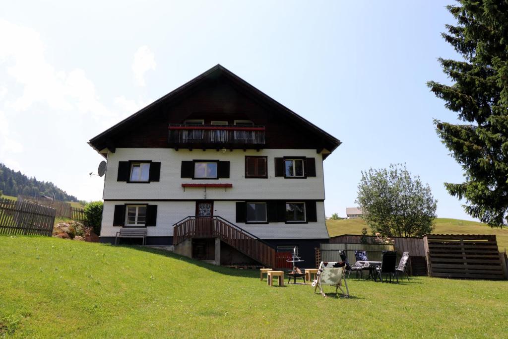 a large house on top of a grassy hill at Hus8 Krumbach in Krumbach