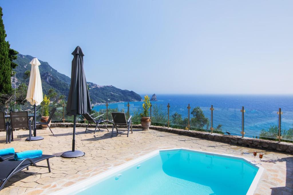 a swimming pool with a view of the ocean at Noir Luxury Suite by CorfuEscapes in Corfu