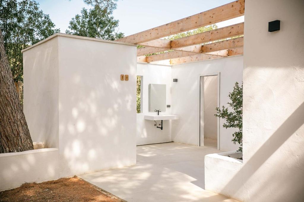 una casa blanca con un fregadero y un árbol en HolaCamp Sitges Garrofer, en Sitges