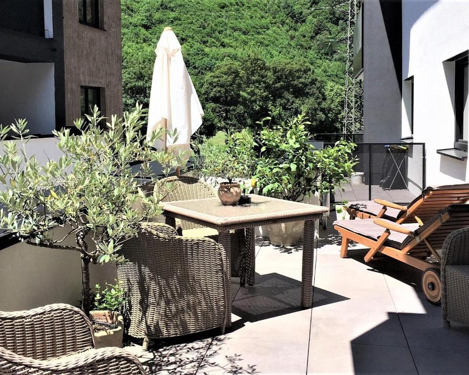 a patio with a table and chairs and an umbrella at monas home mayrhofen in Mayrhofen