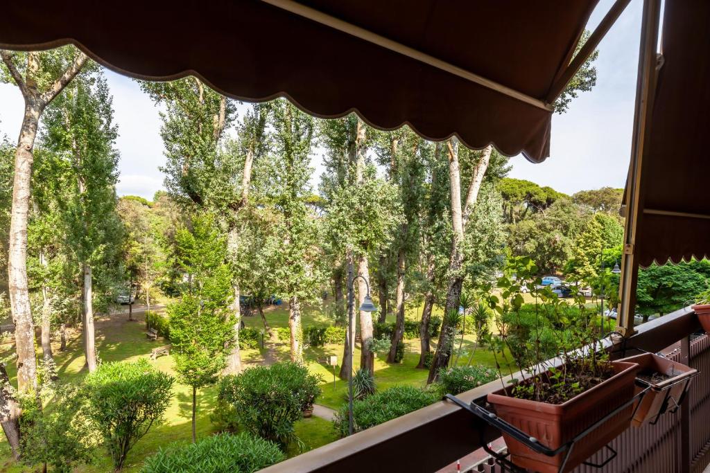 een balkon met uitzicht op een park met bomen bij La Casa nel parco in Viareggio