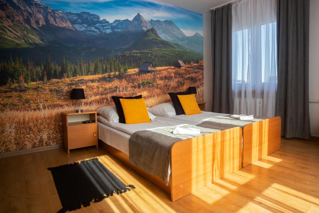 a bedroom with a large bed with a mountain mural at Gościniec Wierchowy in Białka Tatrzańska