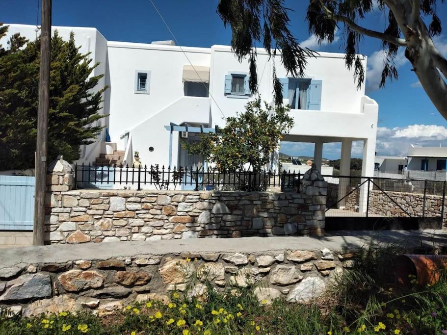 una casa blanca con una pared de piedra delante de ella en Lia's Home, en Mármara