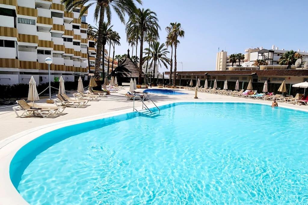 una grande piscina con sedie e un hotel di Encanto Studio a Playa del Ingles