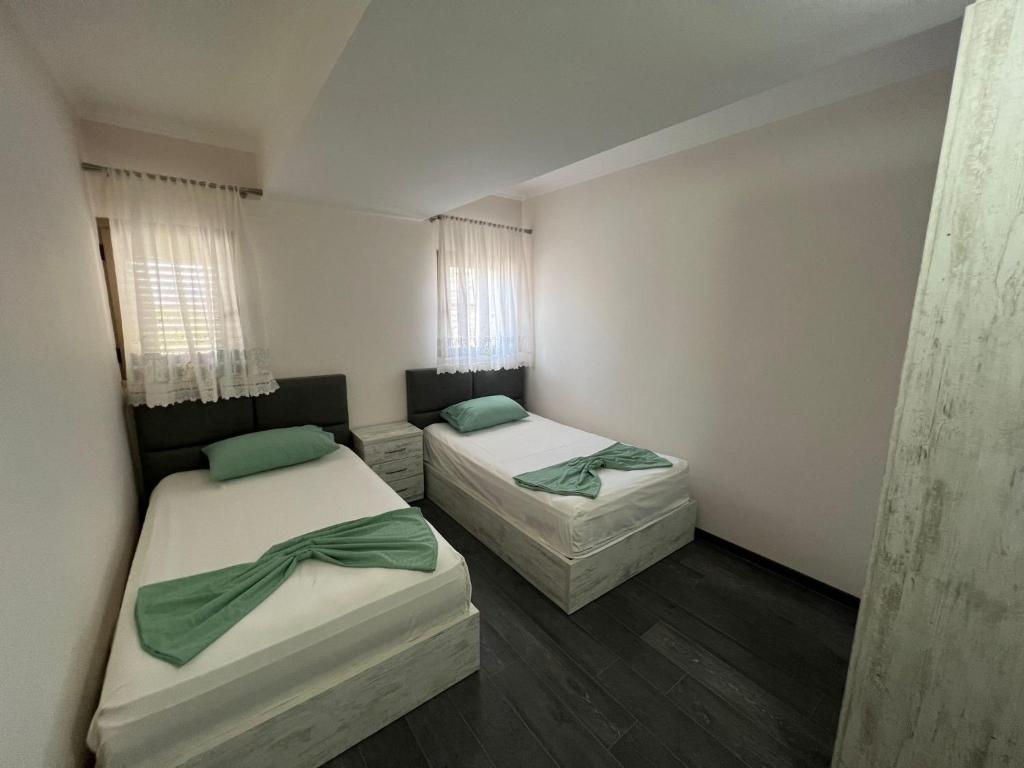 2 camas en una habitación pequeña con ventanas en Union Villa en Shkodër