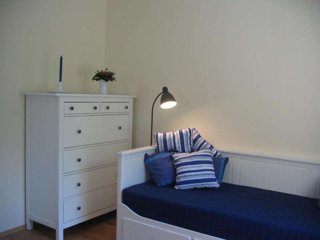 a bedroom with a blue bench with a lamp and a dresser at Gemütliche strandnahe Ferienwohnung in Bansin
