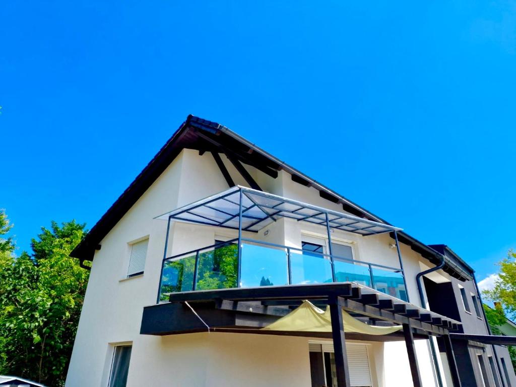 a house with large glass windows on top of it at Moonlight Apartment in Siófok