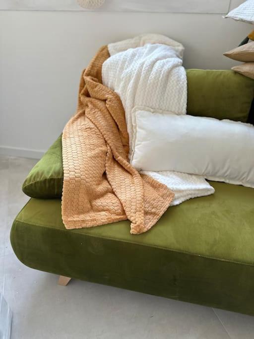 une couverture posée sur un canapé vert dans l'établissement Studio à 2min à pied de la plage, à Cavalaire-sur-Mer