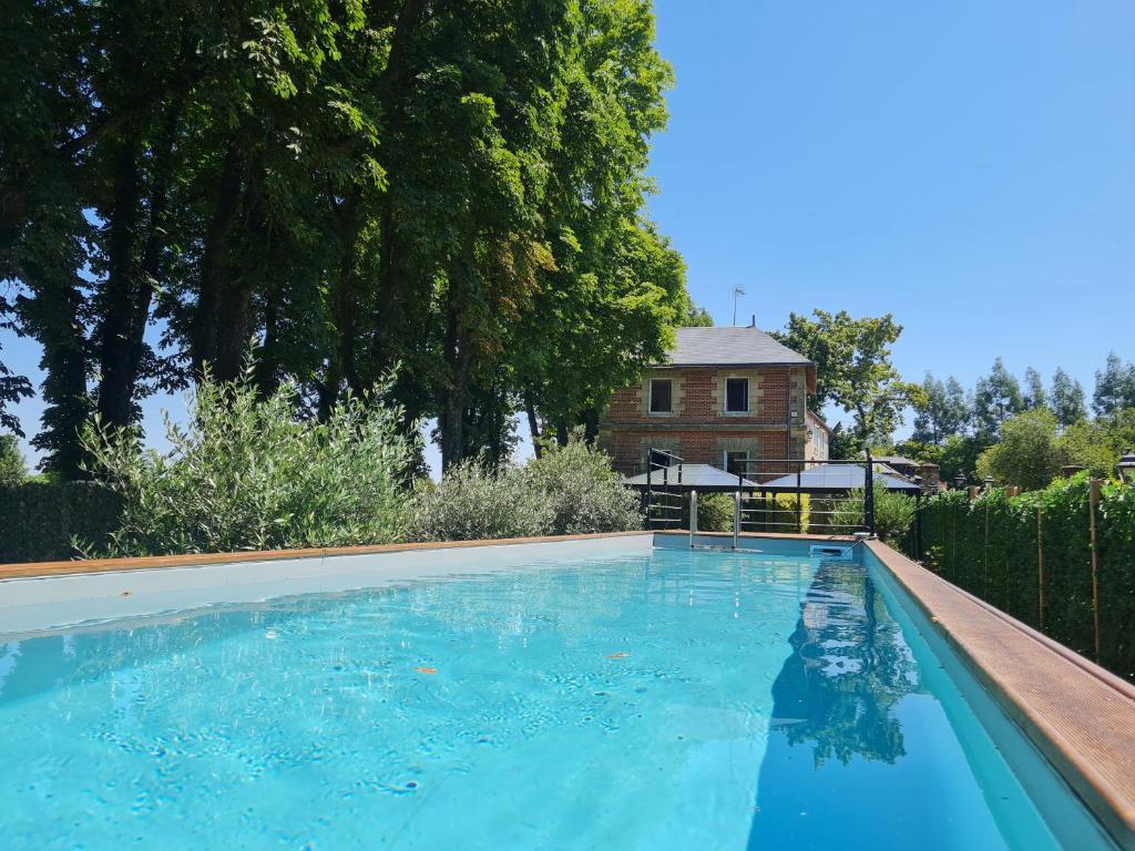 una gran piscina con una casa en el fondo en La Fuye du Chateau de Jallanges pour 17 personnes, en Vernou-sur-Brenne