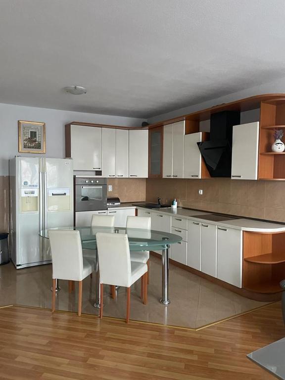 a kitchen with a glass table and white chairs at Apartment Lucy in Makarska
