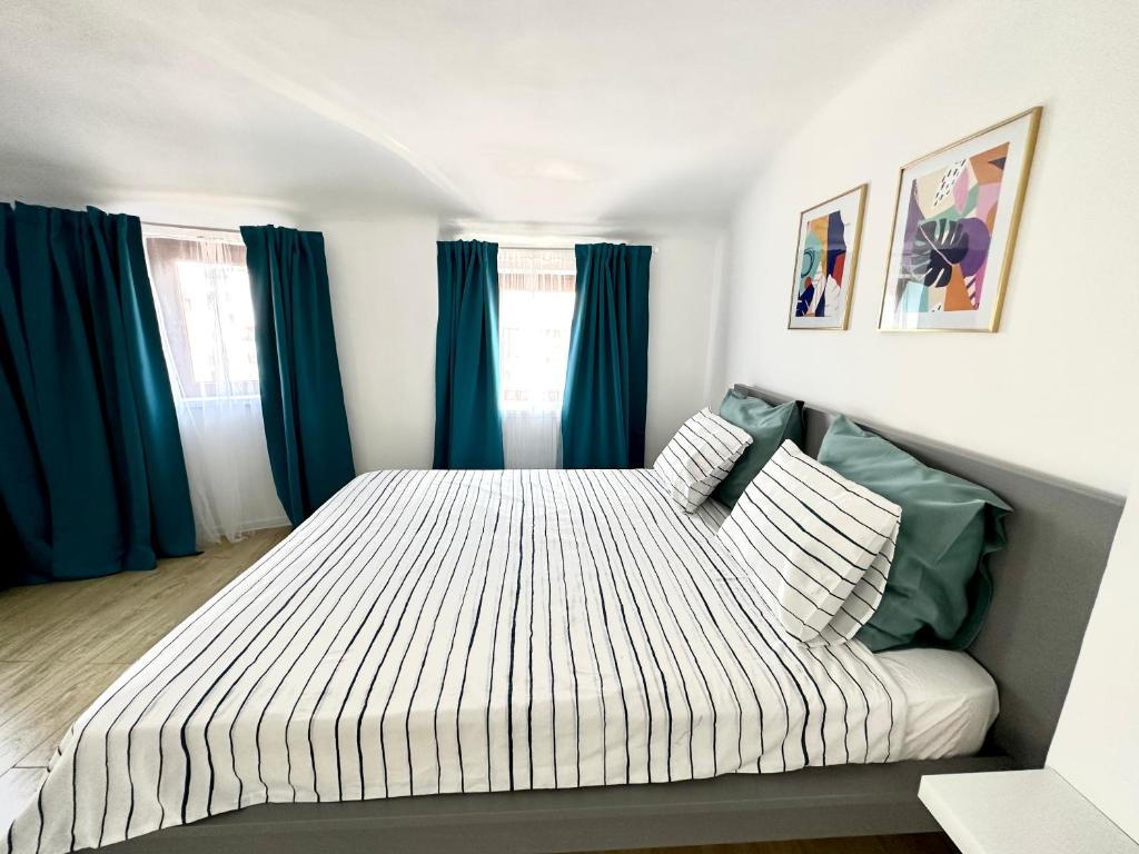 1 dormitorio con 1 cama grande y cortinas azules en Turqoise Central Apartaments, en Bucarest