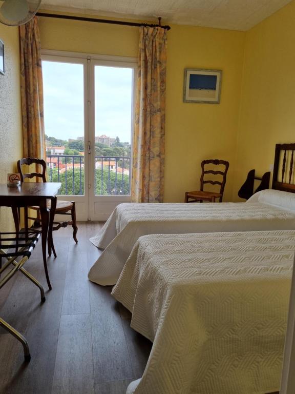 ein Hotelzimmer mit 2 Betten und einem Fenster in der Unterkunft HOTEL AMBEILLE in Collioure