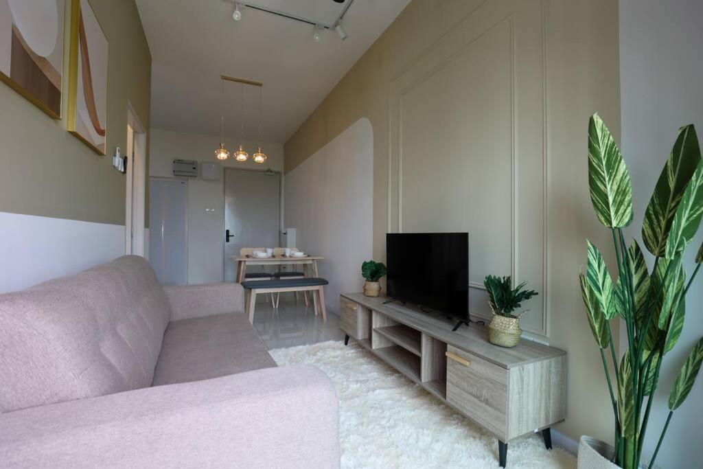 sala de estar con sofá y TV de pantalla plana en 5 Pax The Glenz New Cozy Homestay, en Batu Gugup