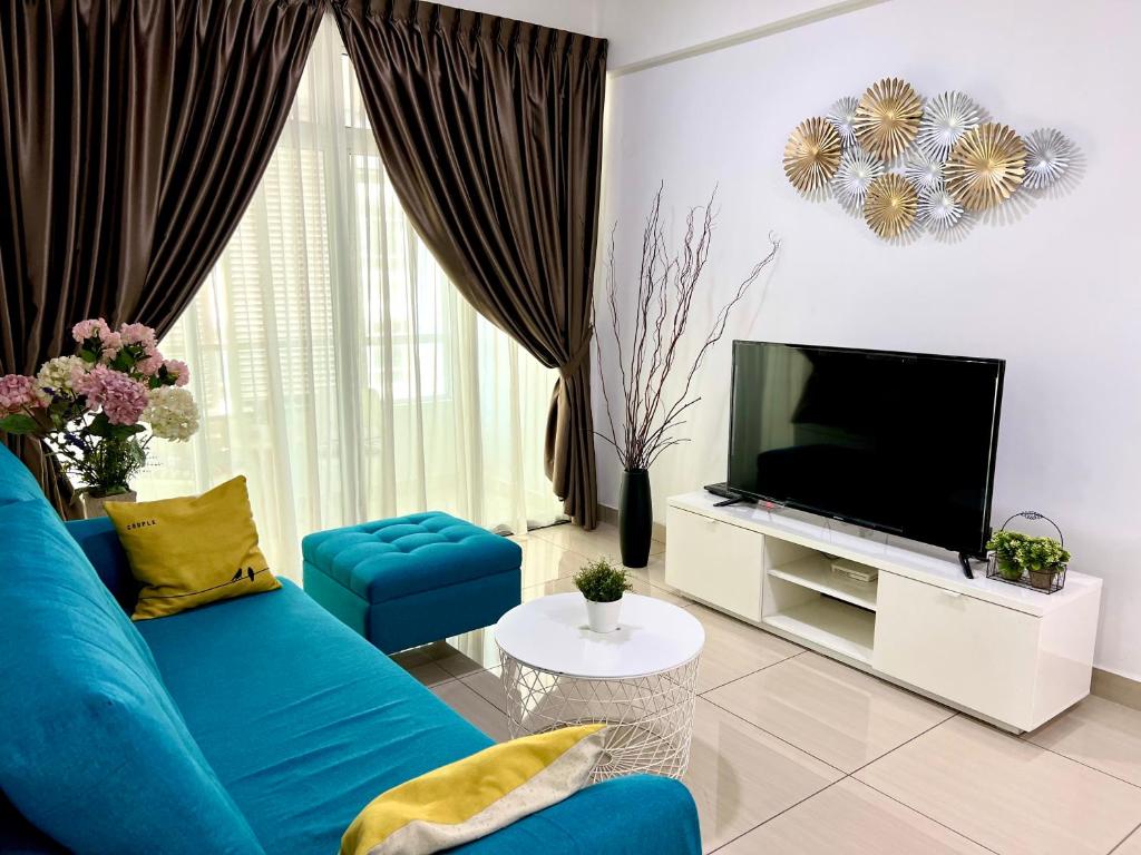 a living room with a blue couch and a tv at 3BR Mount Austin @Midori Green (1 to 8pax) in Johor Bahru