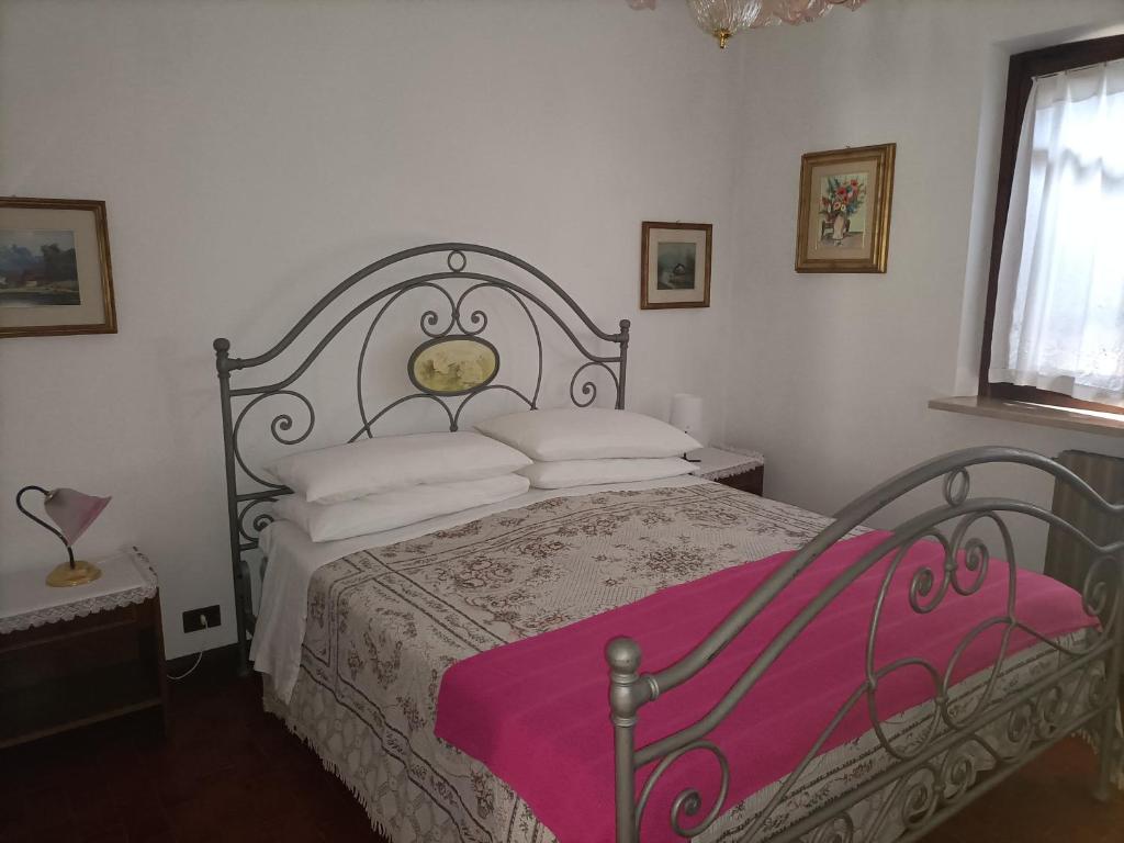 een slaapkamer met een bed met een roze deken erop bij B&B le rose in Crone