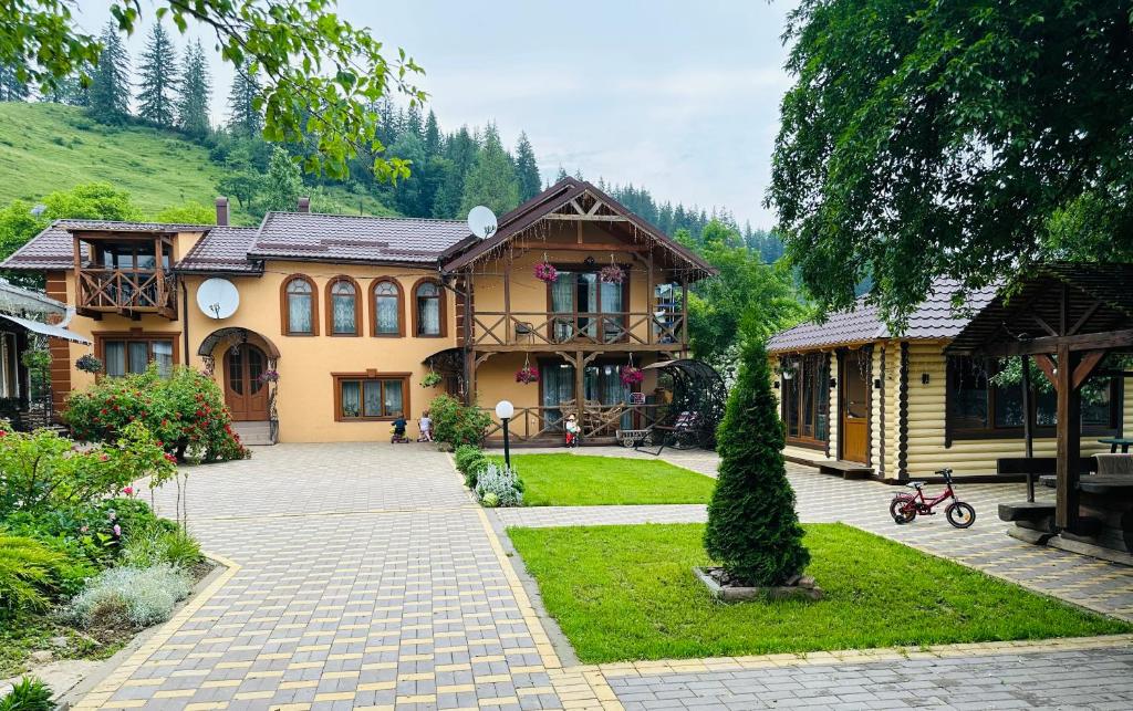 a large house with a garden in front of it at Rodynnyi Zatyshok in Verkhovyna