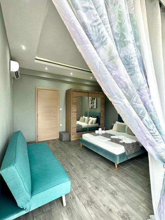 a bedroom with a bed and a couch and a window at ENDLESS BLUE Dream Villa in Paleo Tsifliki