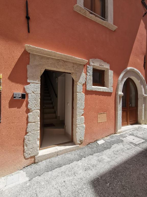 un edificio con una puerta y escaleras. en La Margherita, en LʼAquila