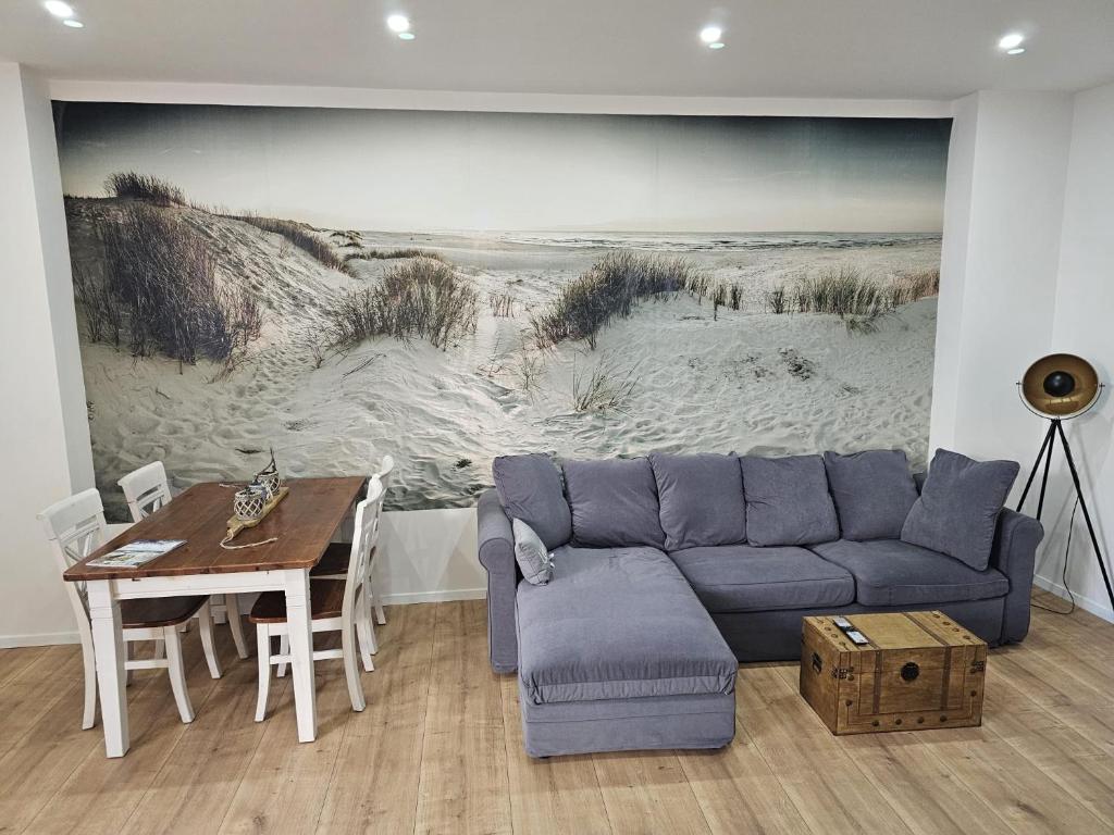 a living room with a blue couch and a table at Küstenzauber - Balkon - Tolle Lage - Netflix in Wilhelmshaven