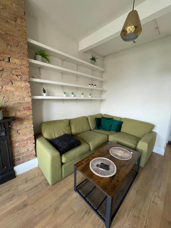 a living room with a couch and a coffee table at Stylish 1BD Flat with Private Terrace - Kilburn in London