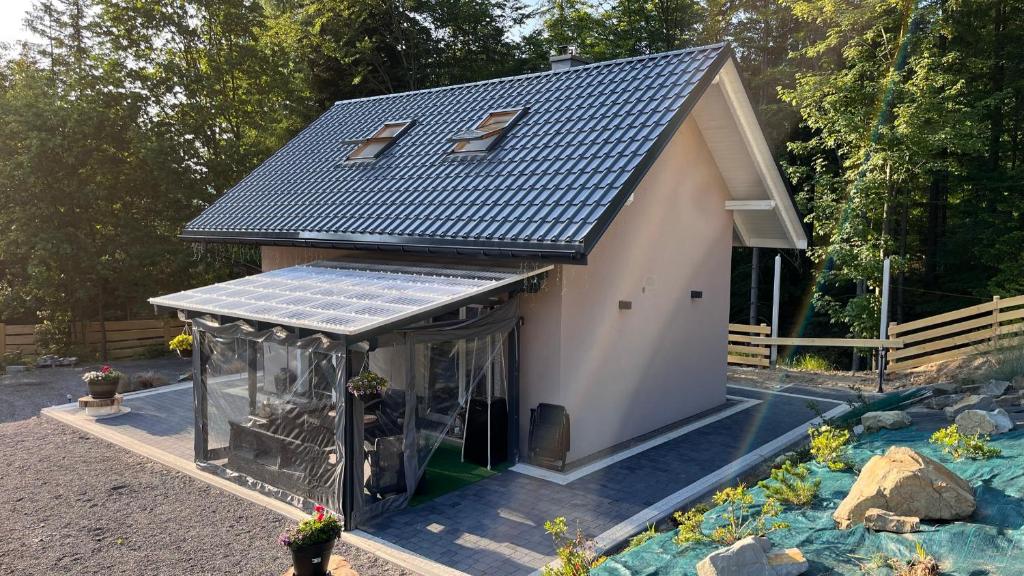 a small house with a solar roof on a garden at Domek Pierwiosnek Ustroń in Ustroń