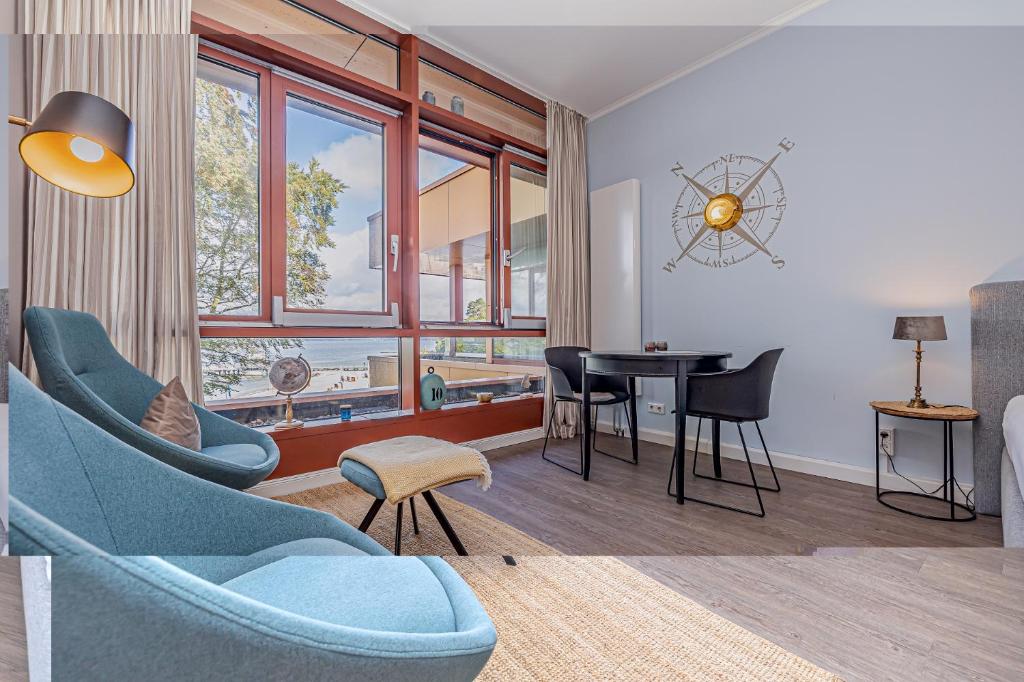 a living room with a blue couch and a table at fewo1846 - Marina del Rey - elegantes Studioapartment mit Meerblick und eigenem Strandkorb in Glücksburg