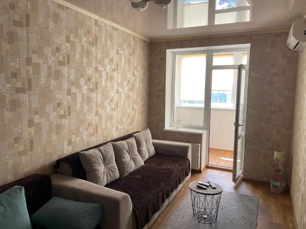 sala de estar con sofá y ventana en Podobovo Horbatko 250м від моря, en Yuzhne