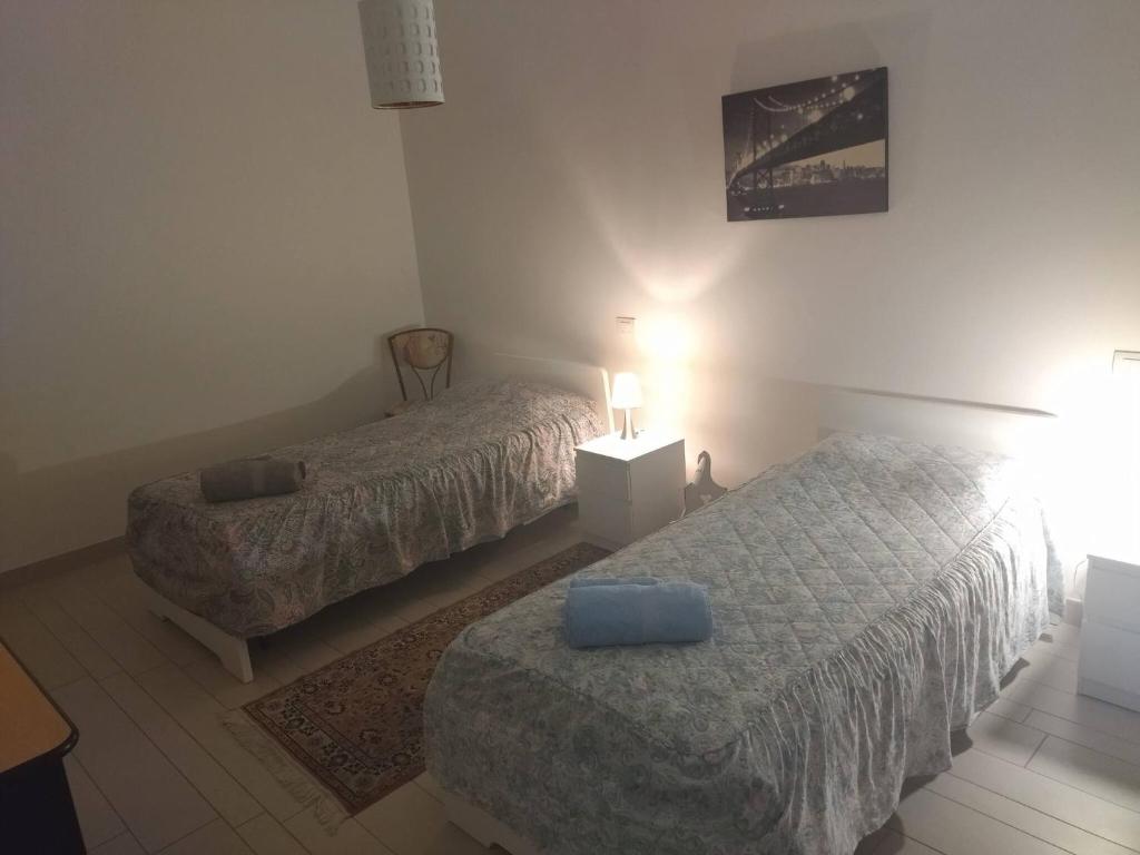 a bedroom with two beds and a table with a lamp at Room in Guest room - Double room between Padua and Chioggia in Brugine